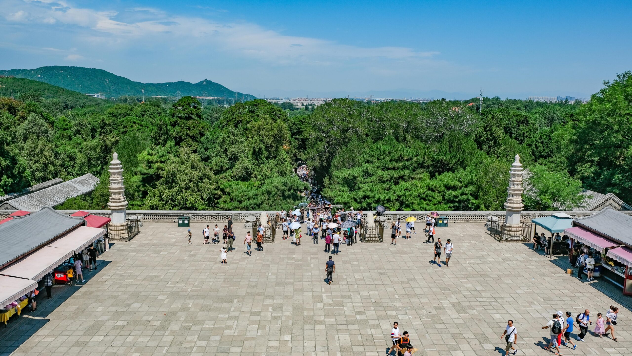Vibrant summer scene of a bustling temple courtyard in Beijing with tourists.