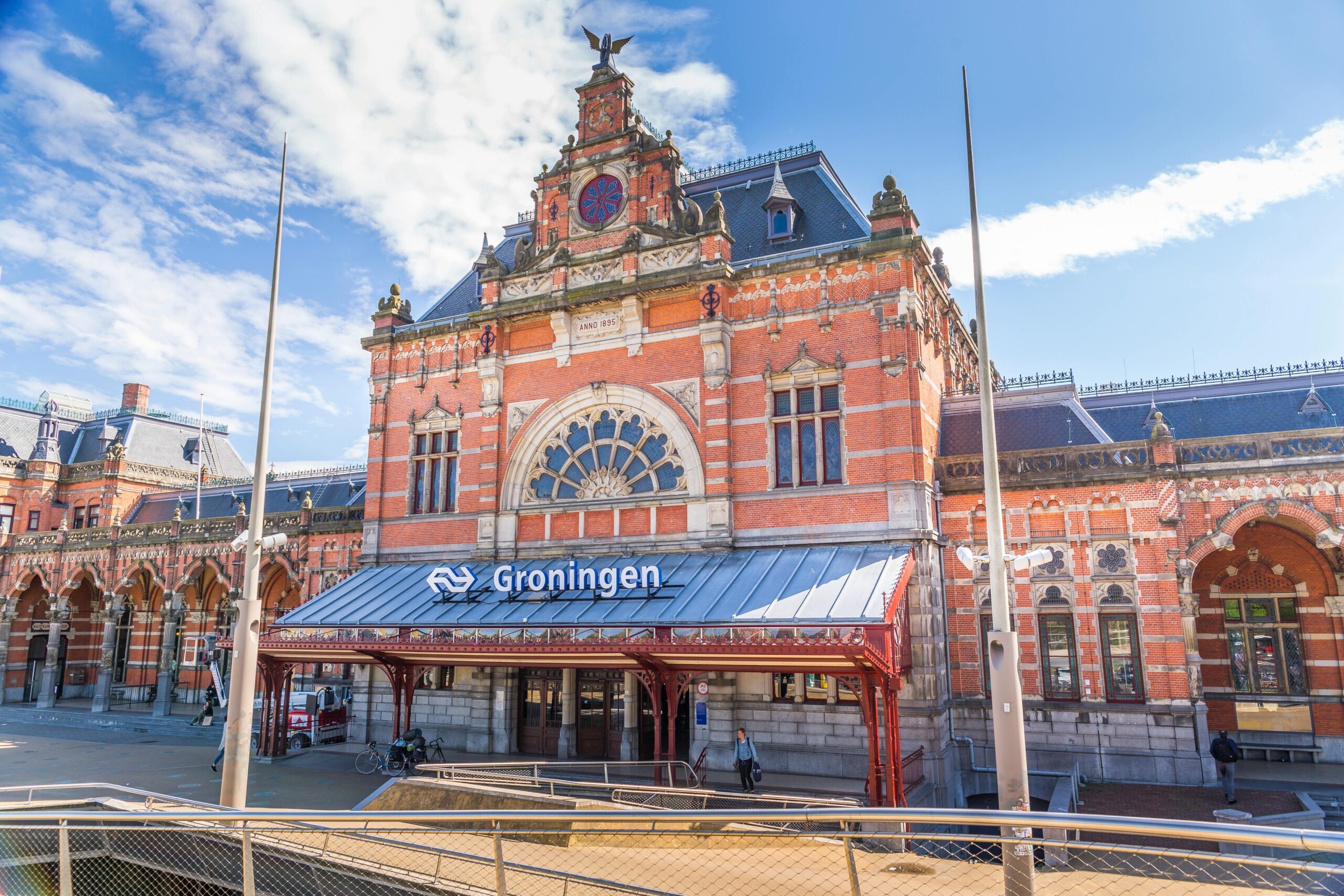 The historic Groningen railway station showcasing stunning architecture under bright skies.
